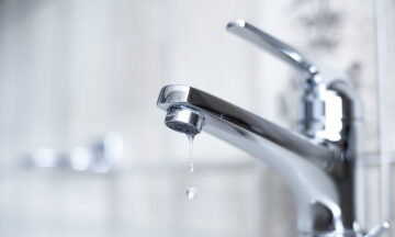 アパートのバスルーム内に水滴を垂らした蛇口